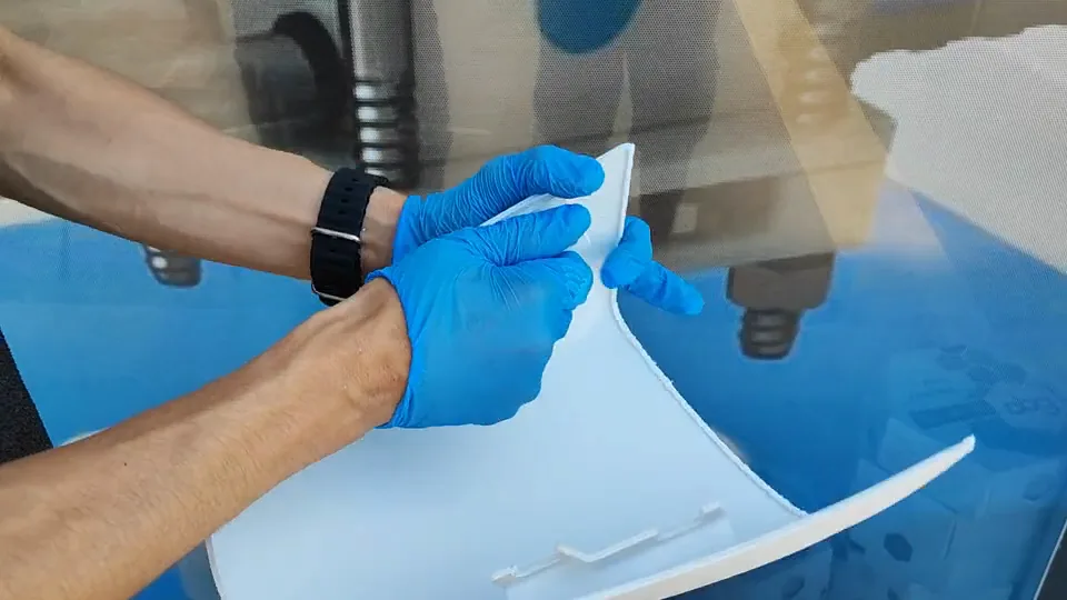 Üretilmiş beyaz parçanın eldivenli ellerle incelenmesi